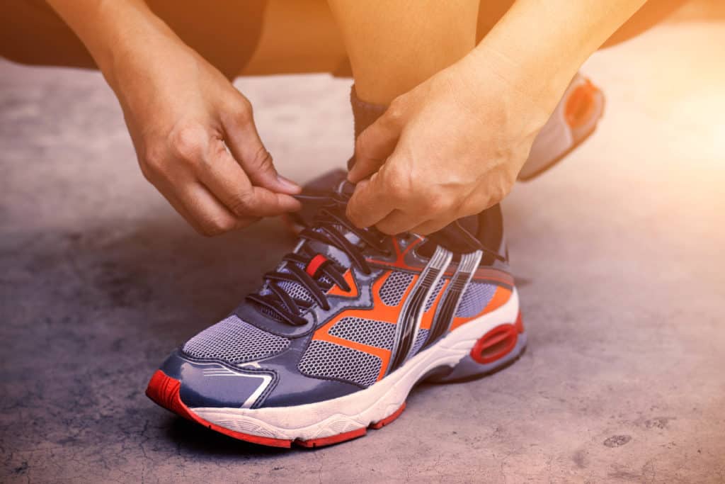 Fitness Tracker beim Schuhe binden am Fuß